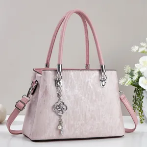 Detailed view of the pink women handbag featuring elegant vertical stripes and metal clover charm.