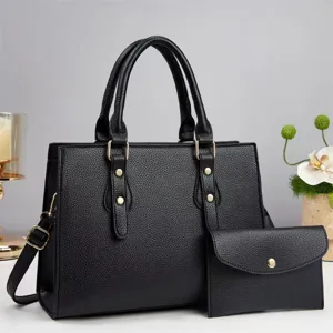 Detailed view of the women's black pebbled leather tote handbag with matching pouch and strap.