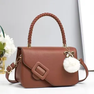 Vue détaillée du sac bandoulière en cuir marron avec poignée tressée et boucle.
