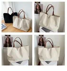 Close-up detail of large capacity casual canvas tote bag with brown handles for daily commuting.