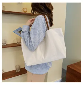 Detailed view of large capacity casual canvas tote bag with brown straps in lifestyle scene.