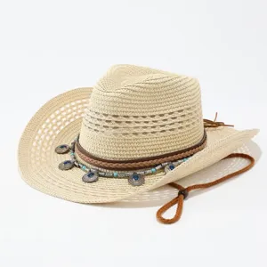 Nahaufnahme des gewebten Stroh-Cowboyhuts mit Perlen-Boho-Anhänger und Kinnriemen.