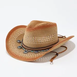 Detailansicht des Western-Strohhutes mit Farbverlauf, geflochtenem Band und Metallanhängern.