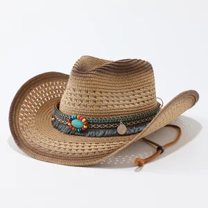 Detailopname van een bruine gegradueerde strooien cowboyhoed met kleurrijke kraalband en franje.