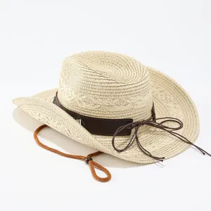 Primo piano dettaglio del cappello da cowboy in paglia con fascia in pelle e sottogola.
