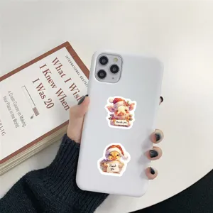 Close-up detail of cute Christmas animal stickers featuring a pig and chick on a phone case.