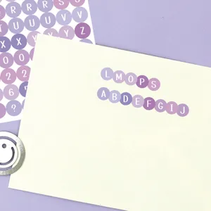 Runder Buchstabenaufkleber Detail, violettes Etikett fuer Tagebuchdekoration und Index.