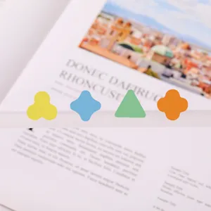 Detail shot of colorful irregular memo stickers on a book page, perfect for journaling and notes.