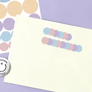 Primo piano di adesivi indice a pois pastello disposti ordinatamente su carta per diario.