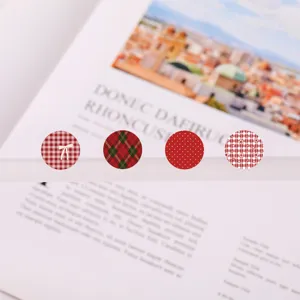 Detailed close-up of decorative red round stickers with various plaid and dot patterns for journaling.
