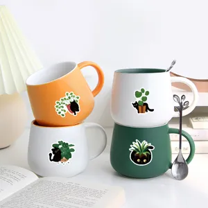 Niedliche schwarze Katze Keramiktasse mit grünem Pflanzenmuster für Kaffee, Tee und Büroalltag.