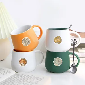Vista detallada de tazas de cerámica con pegatinas de mapamundi vintage, ideales para decoración.