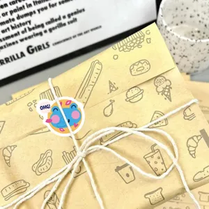 Dettaglio adesivo premio cartone animato, rana blu con testo OMG su carta da imballaggio.