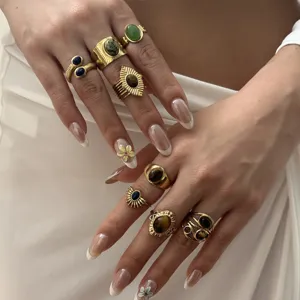 Detailed shot of vintage gold plated stacked rings with irregular lava tiger eye and natural stones.