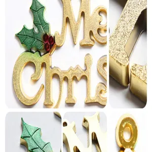 Gold Christmas letter hanging ornament detail view with glitter finish and holly leaves decor.