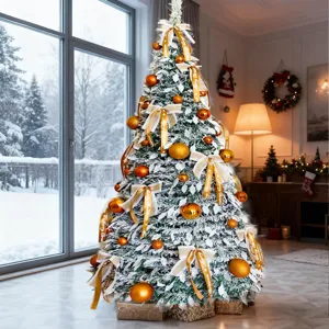 Flocked artificial Christmas tree with golden ornaments and ribbons, perfect holiday decor.