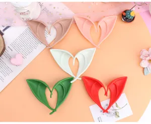 Detailed close-up of colorful cosplay elf ears in brown, pink, white, green and red tones.