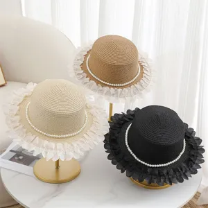 Cappello di paglia piatto dettaglio con perle e bordo di pizzo per vacanza al mare.