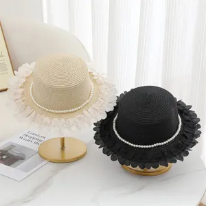 Chic cappello di paglia con catena di perle e bordo in pizzo, perfetto per la spiaggia.