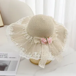 Detailansicht des eleganten beigen Strohhuts mit feiner weißer Spitzenborte und Rosen.