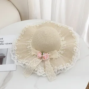 Eleganter Sommer Strohsonnenhut mit zarter Spitzenkrempe und rosa Rosen Blumen Deko.