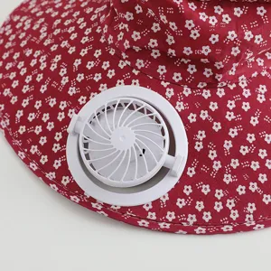Detail shot of women's floral sun hat with built-in mini electric cooling fan for summer outdoor.