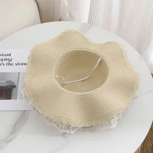 Detailansicht des eleganten Strohhats mit geschwungener Krempe und feiner Spitzenborte.