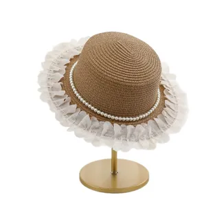 Cappello di paglia estivo da donna con perle e bordo a volant su supporto vista principale.
