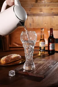 Detailansicht eines einzigartigen fußballpokal förmigen bierglases aus klarem glas.
