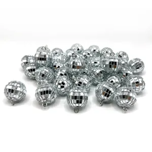 Vue détaillée de petits pendentifs boules à facettes argentées avec anneaux de suspension.