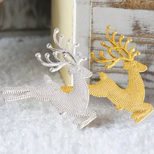 Nahaufnahme von goldenen und silbernen Metall-Rentier-Anhängern, strukturierter Christbaumschmuck.