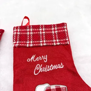Close-up detail of the red Christmas stocking with white plaid cuff and embroidery design.