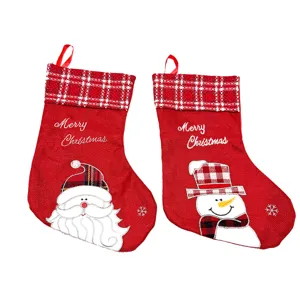 Christmas stocking detail showing Santa and snowman embroidery with red plaid cuff.