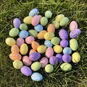 Bunte Mini-Ostereier verstreut auf grünem Gras, ideal für Frühlingsdekoration und festliche Geschenke.