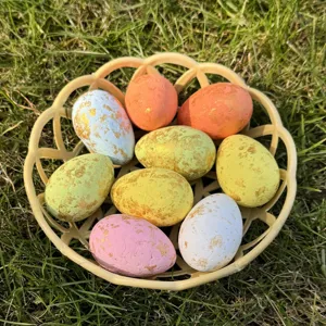 Colorful Easter eggs with gold flecks in a basket, detailed shot of holiday decor toy.