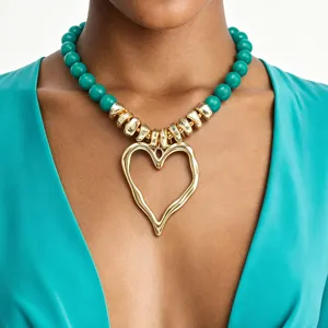Collier ras de cou audacieux avec pendentif cœur, perles acryliques vertes et intercalaires.