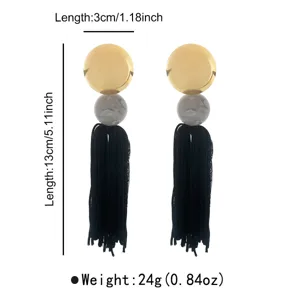 Close-up detail view of bohemian long tassel earrings with stylish gold disc and black fringe element.
