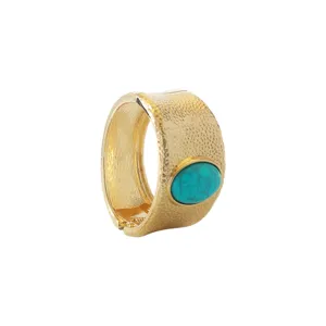 Wide textured gold-tone hinged bangle bracelet with an oval turquoise resin stone center.