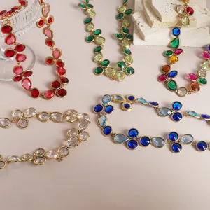 Close-up detail shot of colorful rhinestone teardrop geometric pendant necklaces on display.