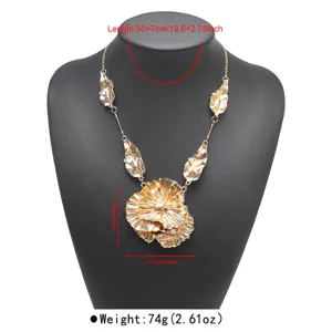 Detailed view of the gold statement necklace with irregular leaf and flower pendants.