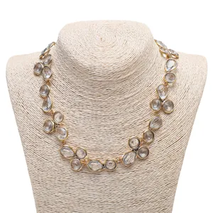 Close-up detail of the exaggerated rhinestone drop necklace with sparkling crystals and gold finish.