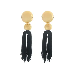 Close-up of bohemian long gold disc and black tassel earrings detail design.