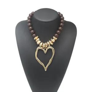 Collier de clavette stylé style doux et cool avec perles marron foncé et pendentif cœur doré.
