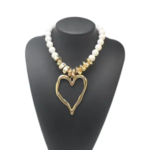 Collier statement cœur avec perles acryliques blanches et pendentif doré pour style tendance.