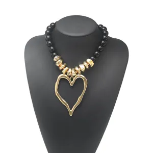 Collier ras du cou avec pendentif grand cœur exagéré, perles acryliques et intercalaires.