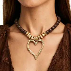 Collier ras de cou chic avec grosses perles en acrylique et pendentif coeur dore tendance