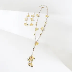 Gold leaf tassel Y necklace and matching earrings detail shot, minimalist jewelry style.
