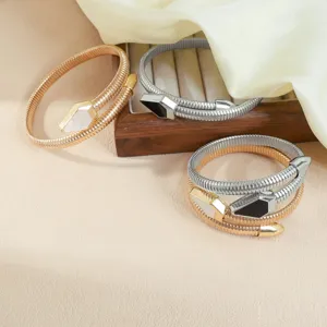 Vista detallada de pulseras de serpiente flexibles en tonos dorados y plateados con incrustación.