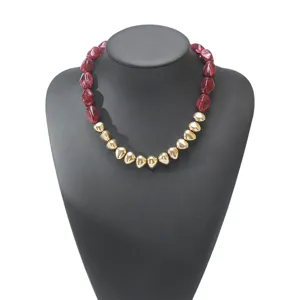 Close-up details of the vintage irregular red resin and gold geometric beaded collar necklace.