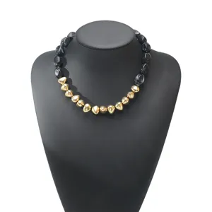 Detail view of the elegant black and gold irregular resin beaded statement necklace piece.